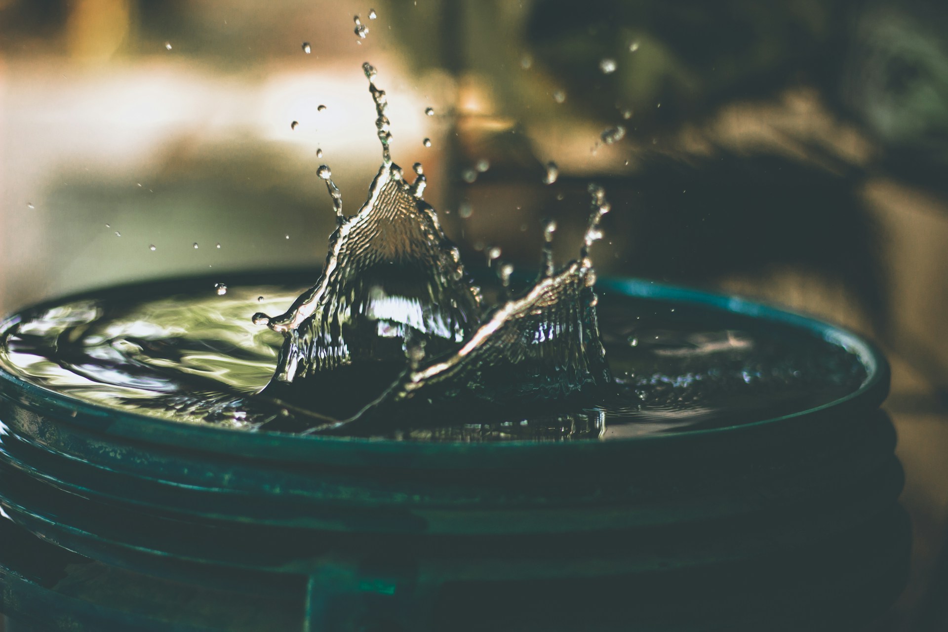 Photo of a barrel full of water after something was dropped in, causing a splash - photo by Amritanshu Sikdar