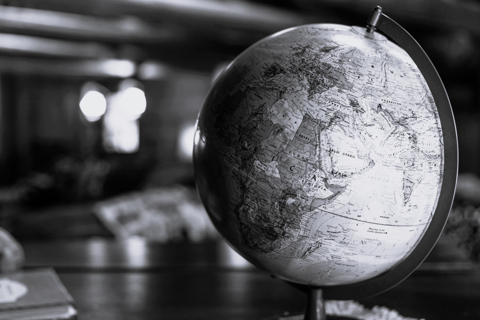 globe sitting on a desk in the foreground with an out-of-focus background